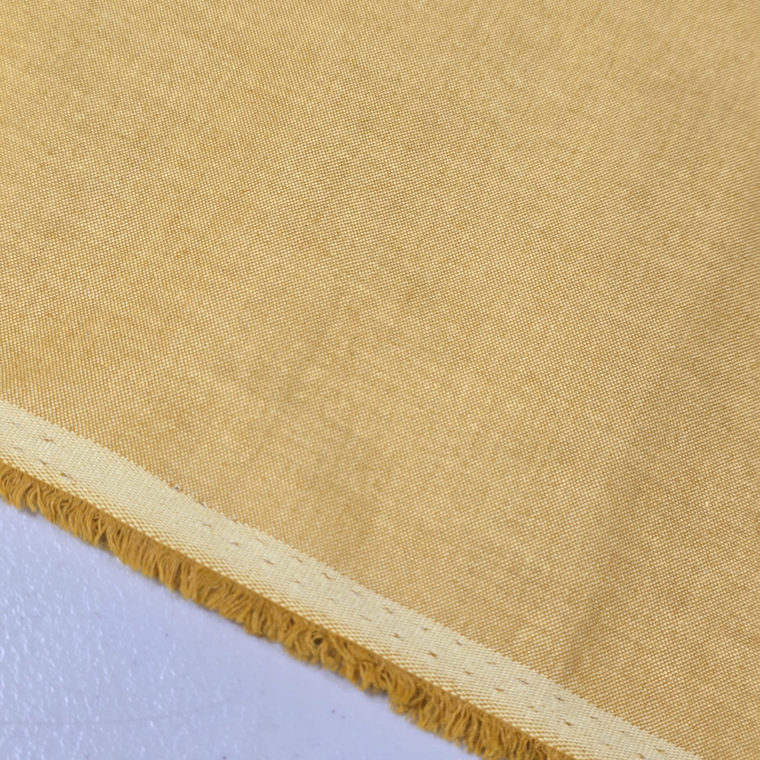 Camel 100% Cotton Chambray fabric draped to display its soft lightweight woven texture, 58-inch wide dressmaking fabric sold by the metre.
