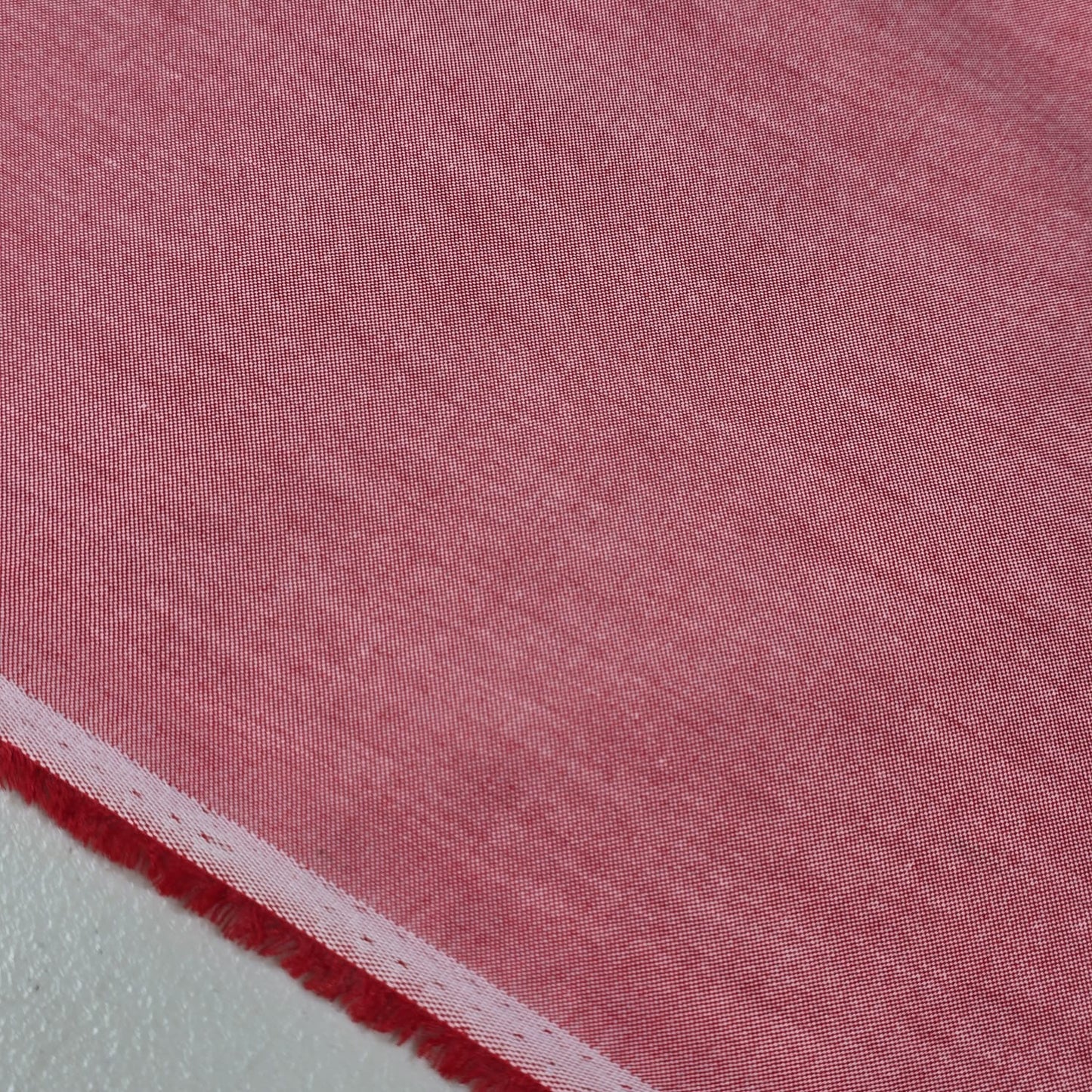 Dusty Rose 100% cotton chambray fabric draped to showcase its soft lightweight woven texture, 58-inch wide dressmaking fabric sold by the metre.